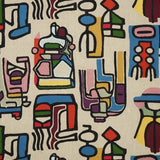 A close-up of a woven textile featuring an abstract, colorful geometric pattern on a light beige background.