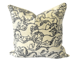A square decorative throw pillow featuring a black line art print of running horses on a warm cream fabric background, shown against a plain white background.