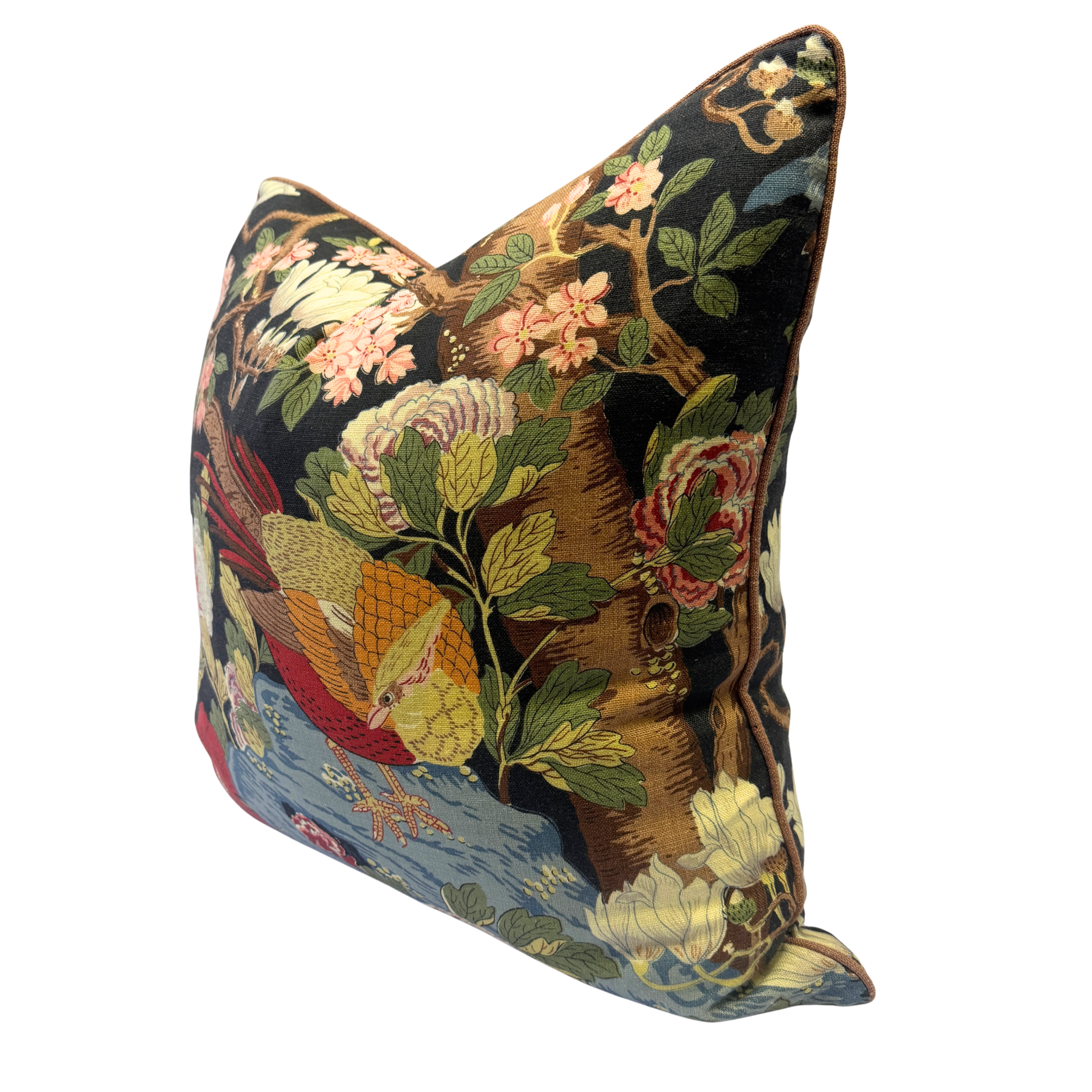 A square decorative throw pillow featuring an intricate tapestry-style botanical and bird pattern on a black background, with pink flowers, green leaves, and a blue water scene at the bottom.