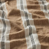 A close-up of a textured woven fabric with vertical stripes in warm brown, off-white, and dark charcoal gray.