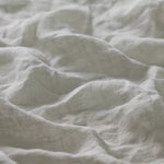 Linia Sheer Tiamo Laurel off-white linen fabric with a soft, textured weave and gentle shadows.
