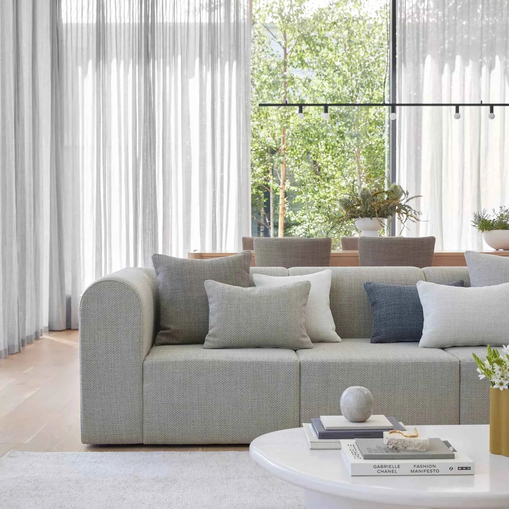 Modern living room with a gray sectional sofa. Fabric by Warwick Fabrics