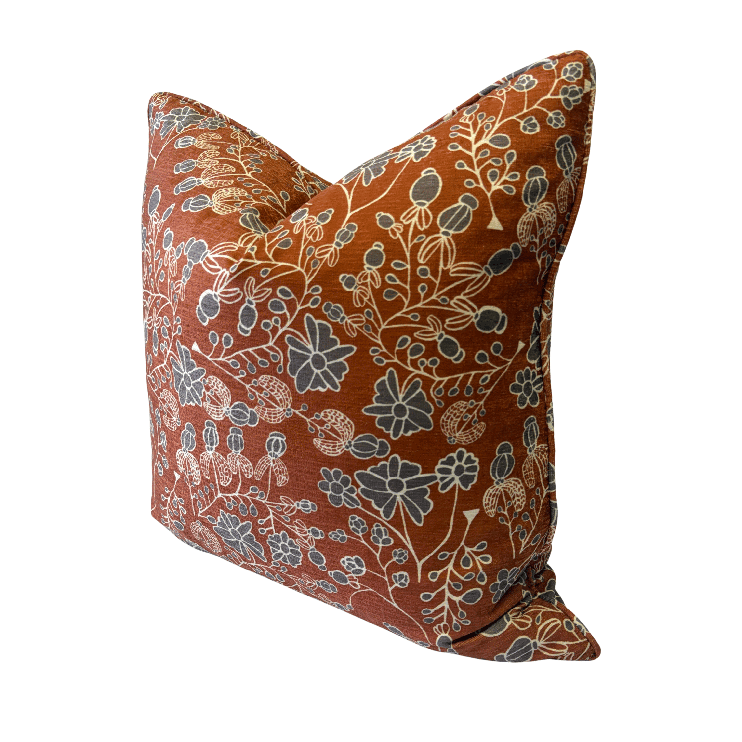A square decorative throw pillow with a rust-orange background and an intricate botanical pattern in muted blue-gray and cream, shown on a plain white background.