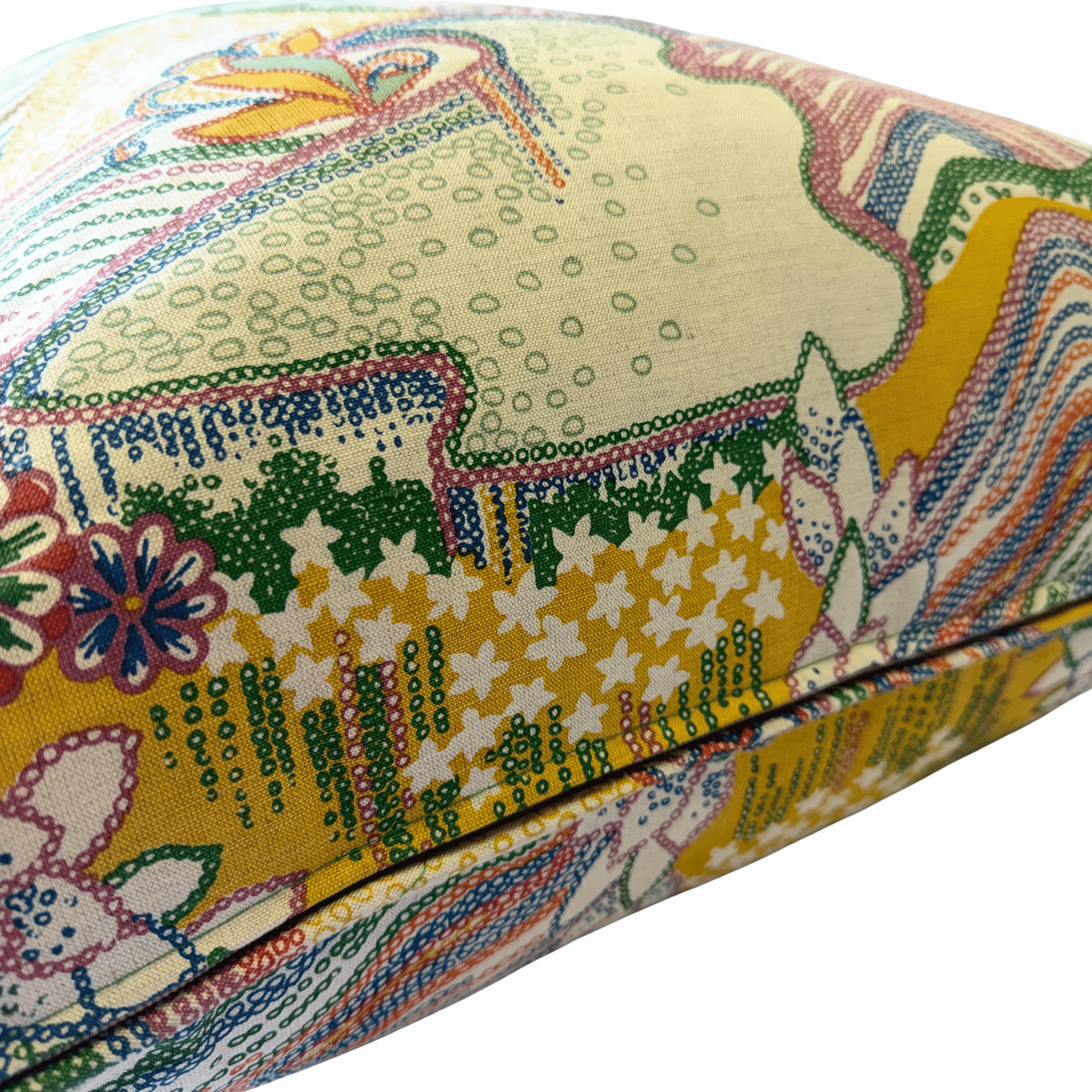 A close-up of a decorative throw pillow featuring a vibrant, multicolored botanical and abstract pattern on a cream-colored fabric background.